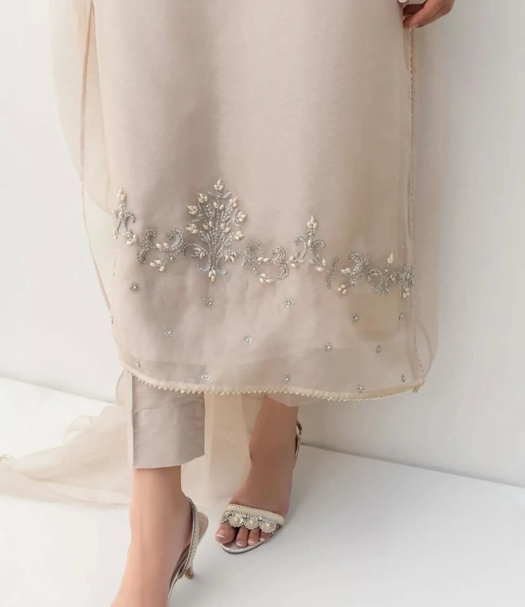 New Arrival - Pre-Booking - 4pcUnstitched - Read y-to-wearThis elegant white outfit features intricate handwork with pearls and Swarovski crystals on the shirt’s daaman, neck, and sleeves.The organza dupatta is (2)