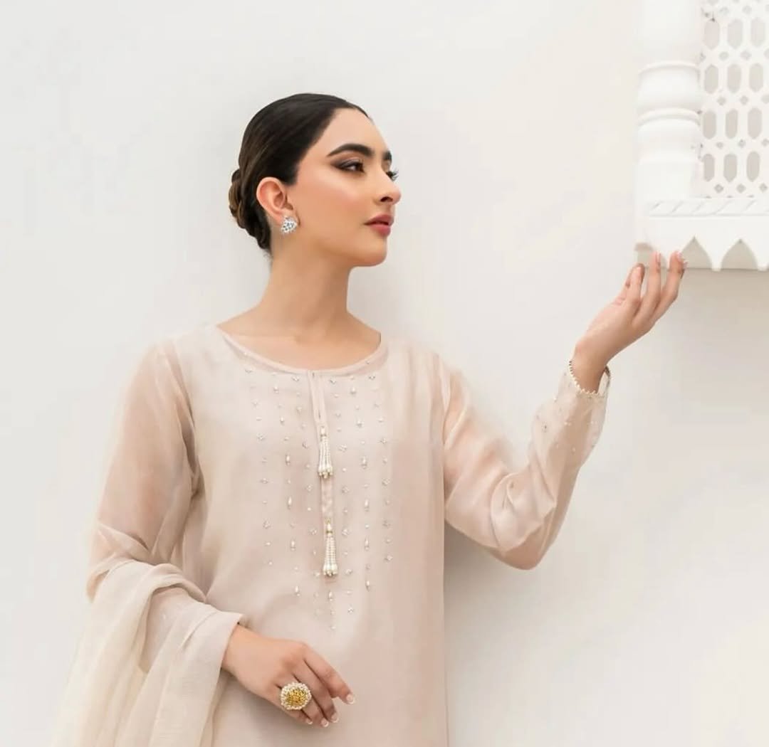 New Arrival - Pre-Booking - 4pcUnstitched - Read y-to-wearThis elegant white outfit features intricate handwork with pearls and Swarovski crystals on the shirt’s daaman, neck, and sleeves.The organza dupatta is (4)